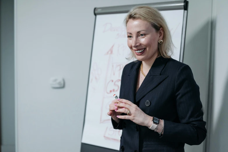 a woman holding a pen in her right hand and smiling