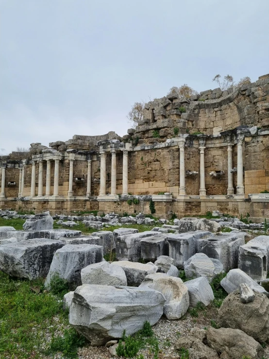 an ancient building with massive rock formations in front