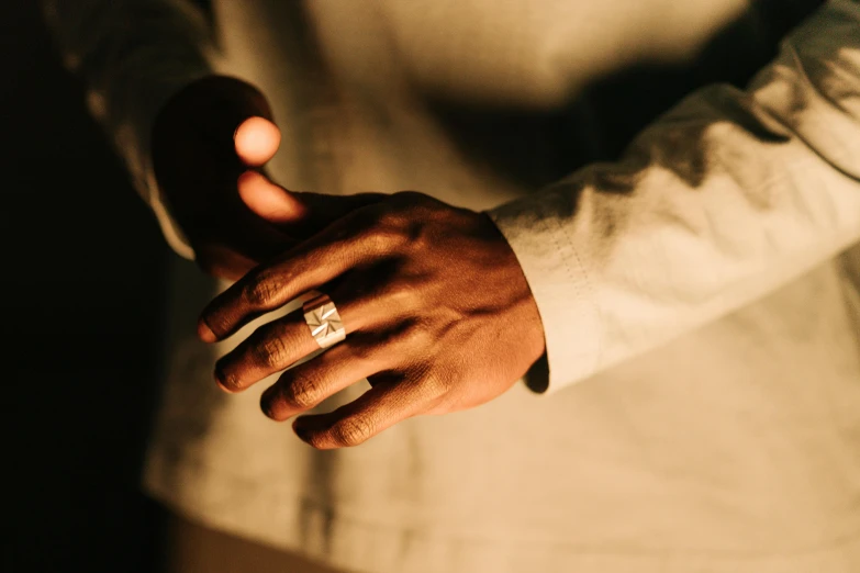 a closeup of two hands that are wearing a ring