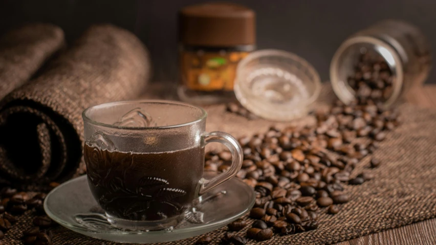 a cup of coffee sitting on top of coffee beans