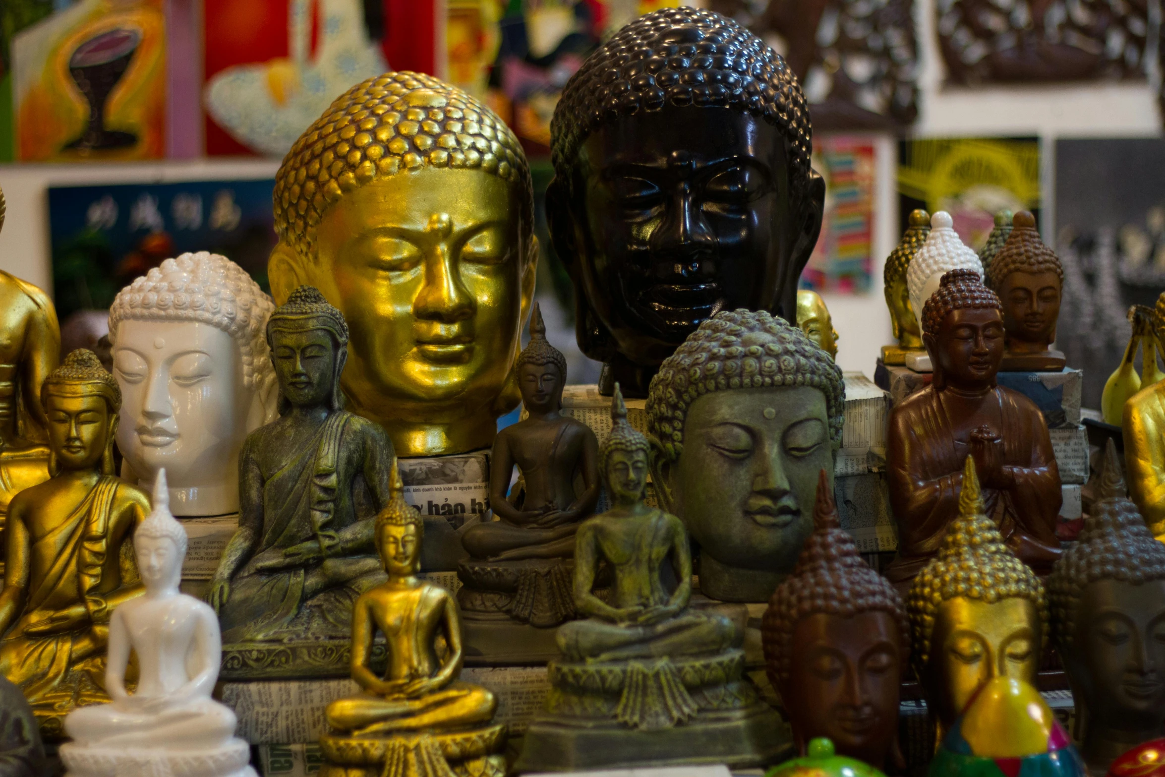 many buddha statues sit on display in a store