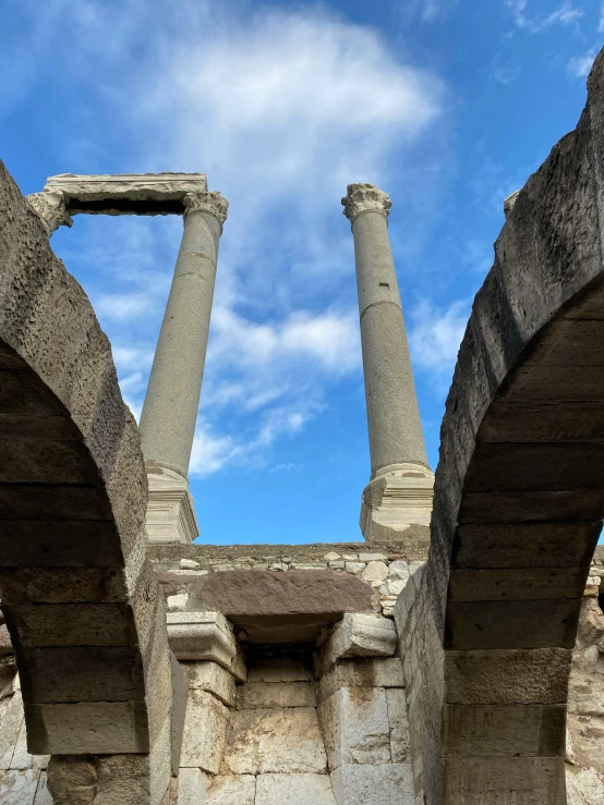 the columns of an ancient temple with blue skies above