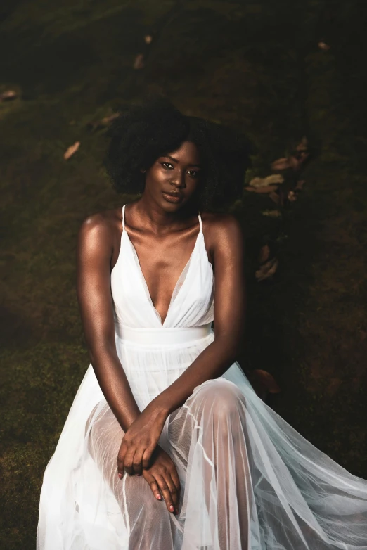 a woman with afro hair is wearing a white dress