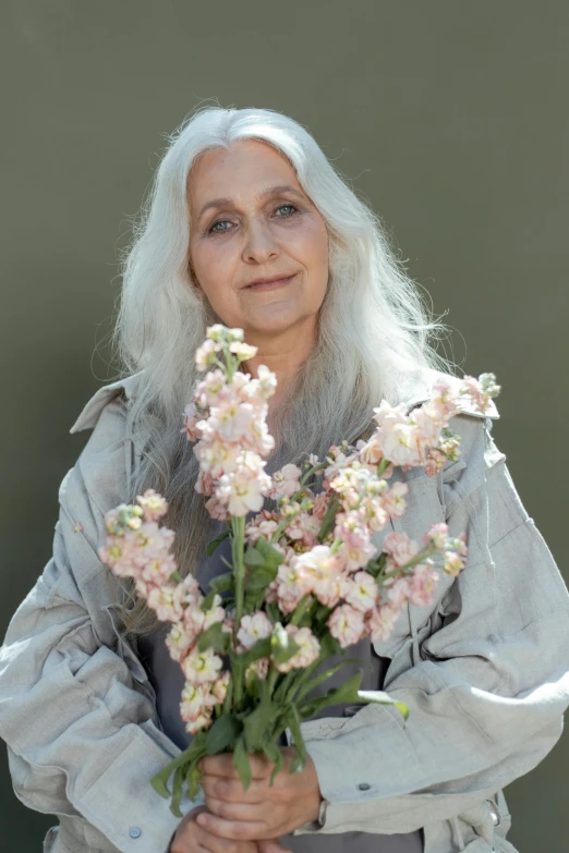 a beautiful woman is holding a bunch of flowers