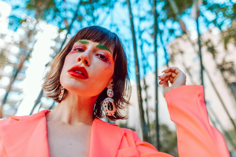 woman in pink blouse holding up her hand while looking up