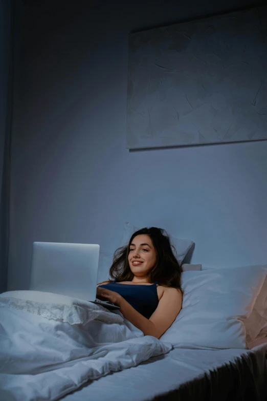 a woman is laying in bed reading a book