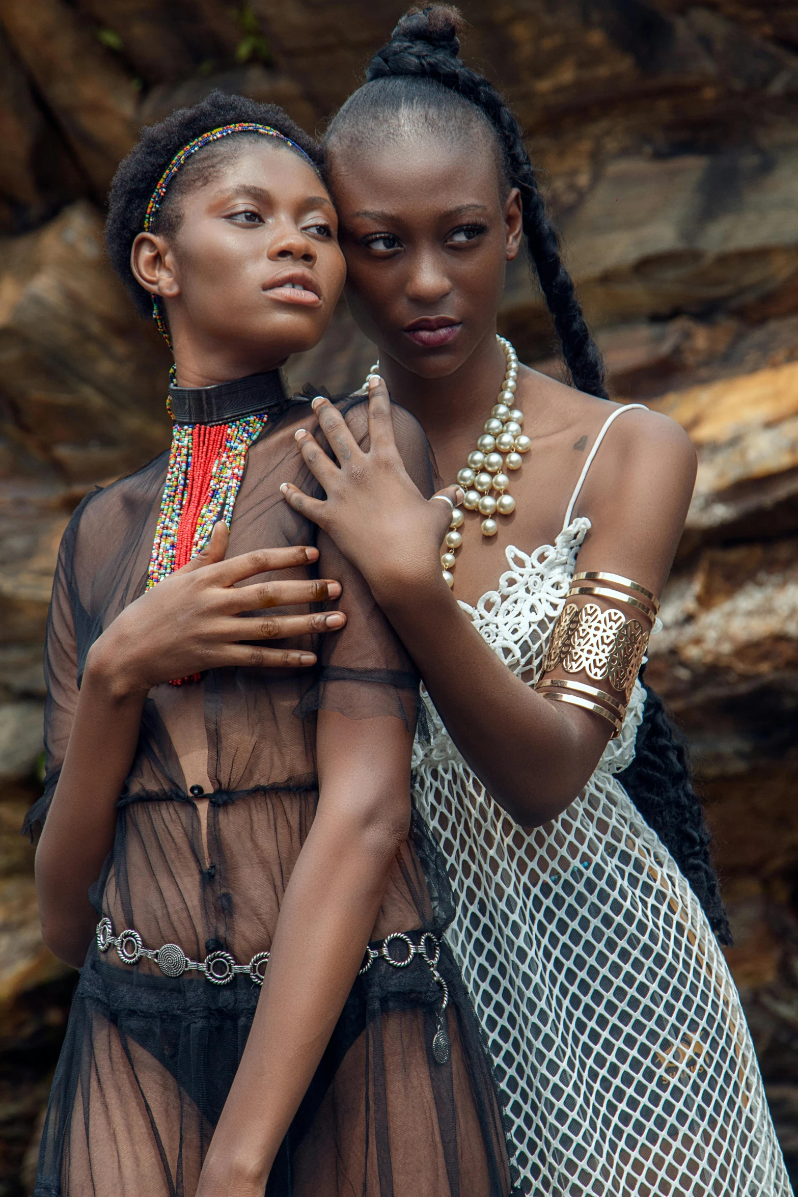 two women standing next to each other with different types of jewelry on their necks