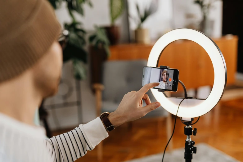 a woman holding a camera while taking a po of a selfie