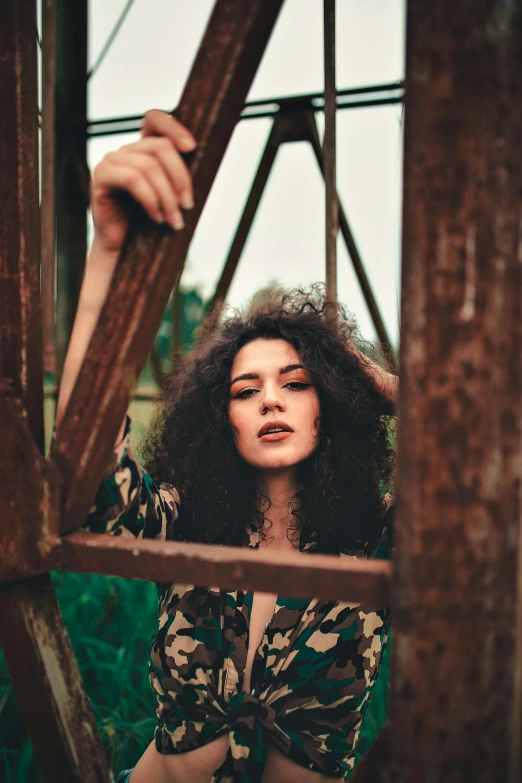 a woman is posing for a po under a bridge