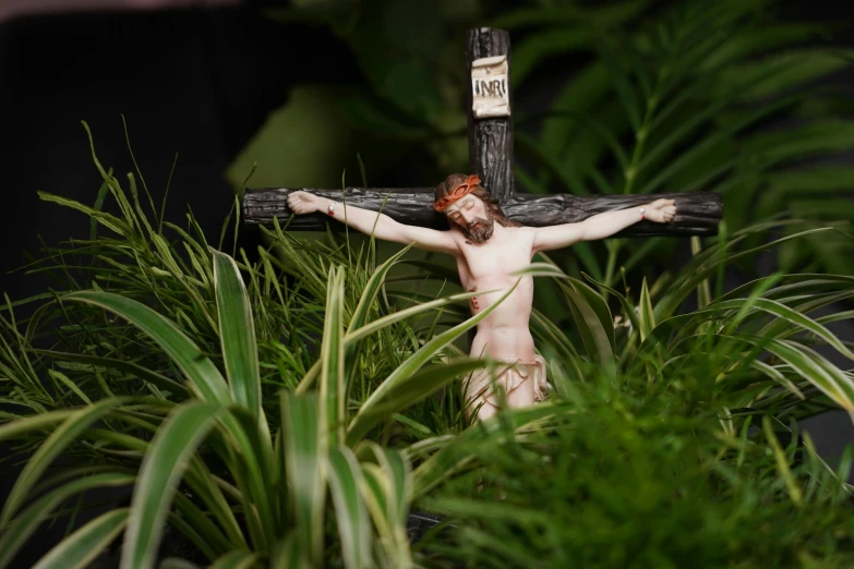 a wooden cross with a jesus statue beside it