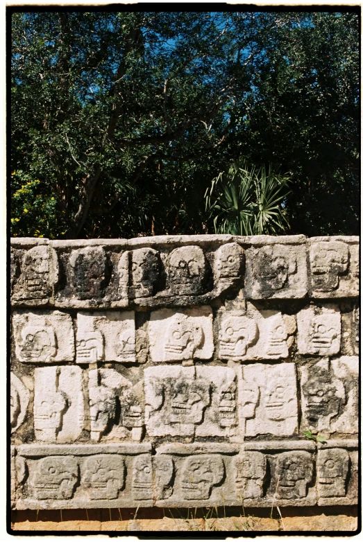 a stone block wall with carvings of animals and birds