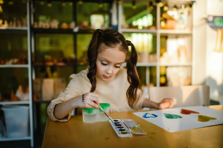 a girl doing arts and crafts at a table