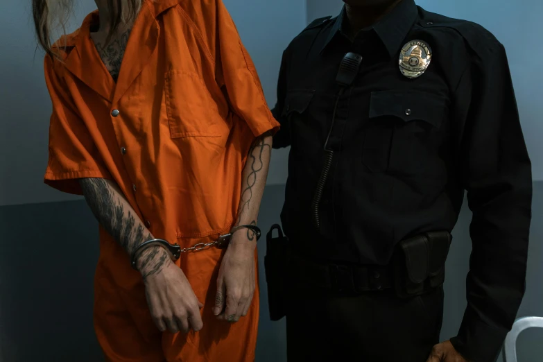 the young man in the orange shirt is standing next to a young woman in a blue room