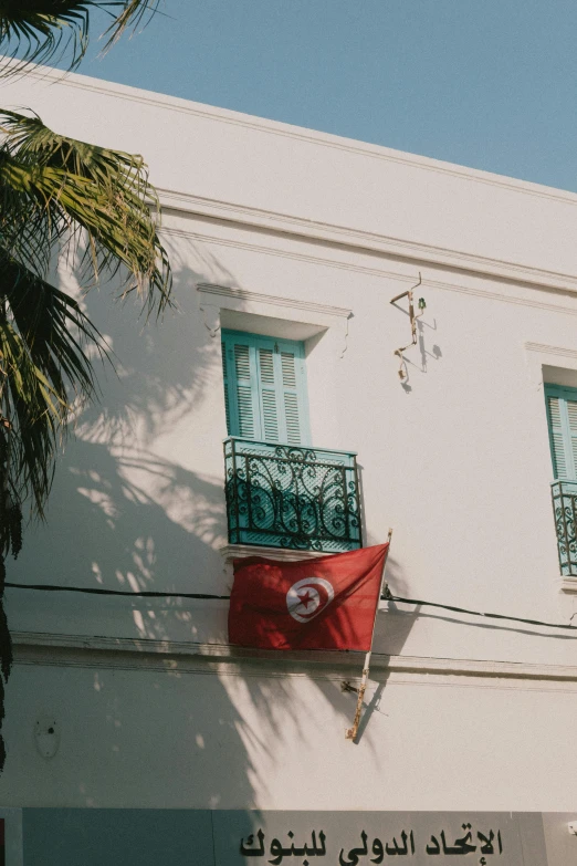 a building with some windows and a flag hanging off the window