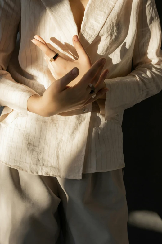 a woman is posing in a white jacket and diamond jewelry