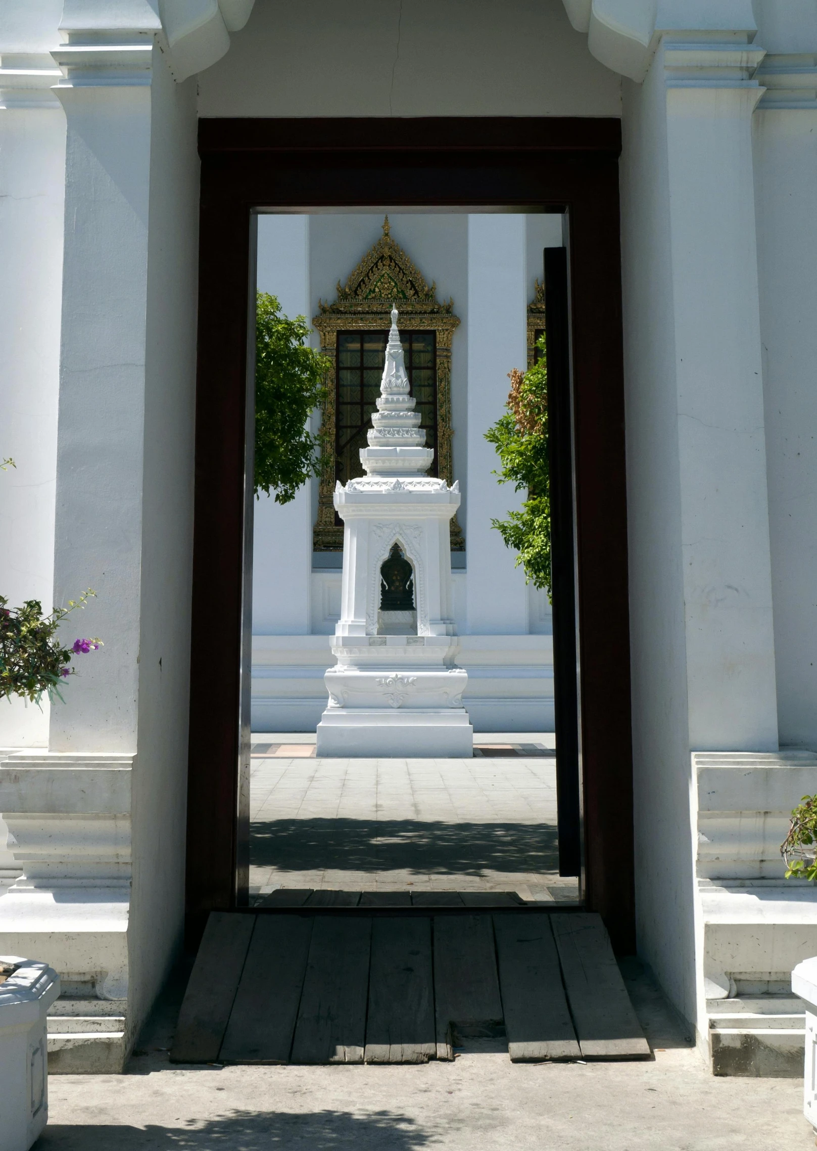 a long archway leads to a white temple