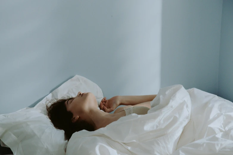 a woman in white bed spread up and sleeping