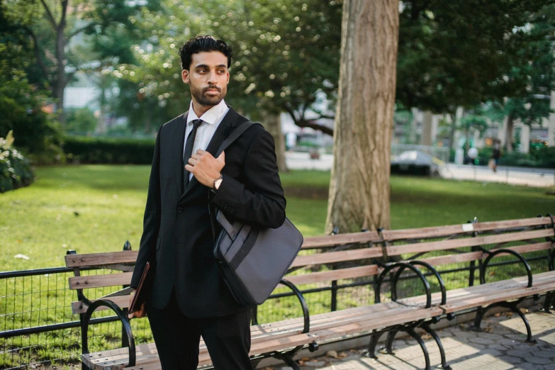 man in suit and tie posing for po while holding briefcase