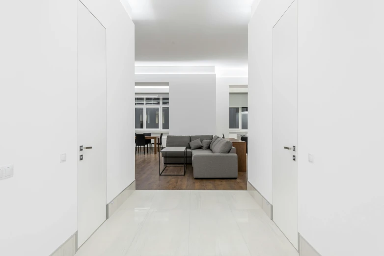 a modern style hallway with white walls and open doors leading into the kitchen