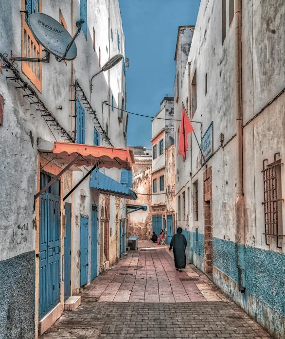 two men are walking down an old - looking city street