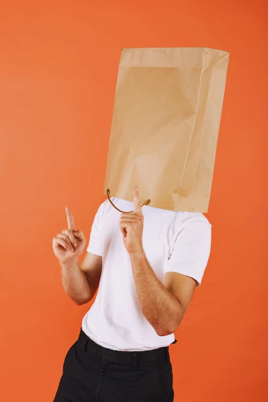 a man in white shirt and black pants holding a paper bag