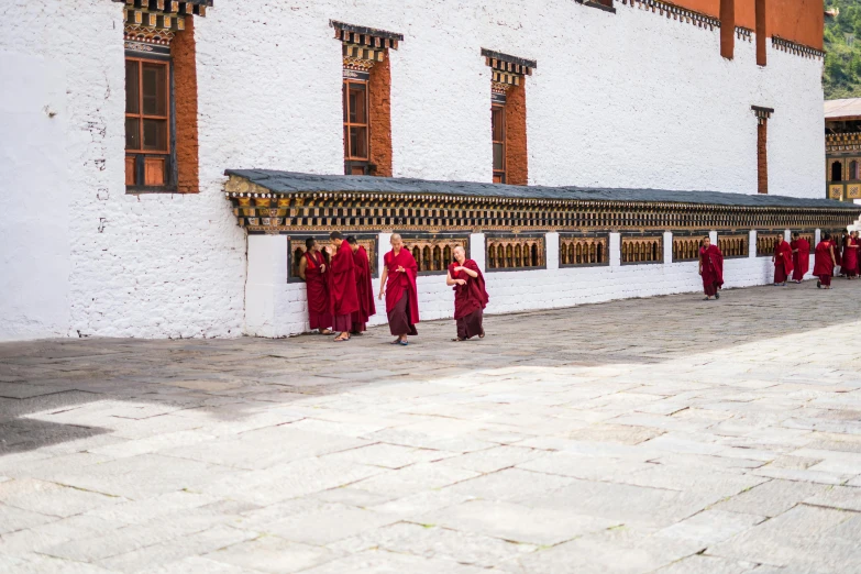 a bunch of monks that are standing in front of a building