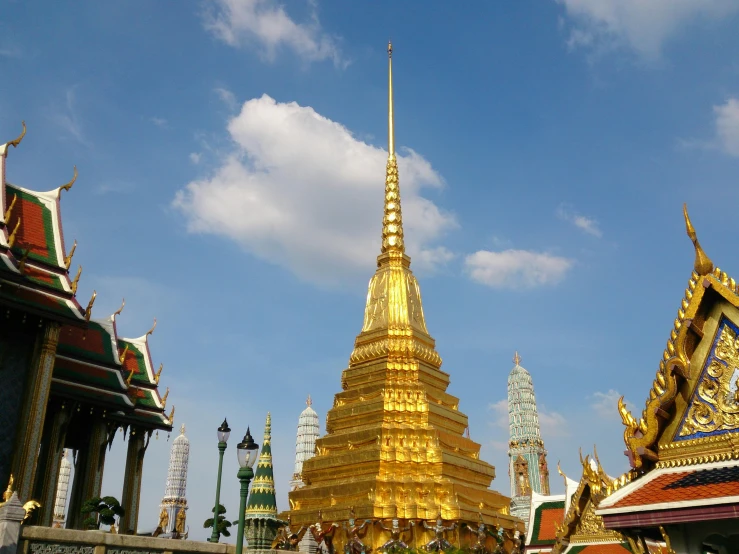 a large gold pagoda near some other buildings