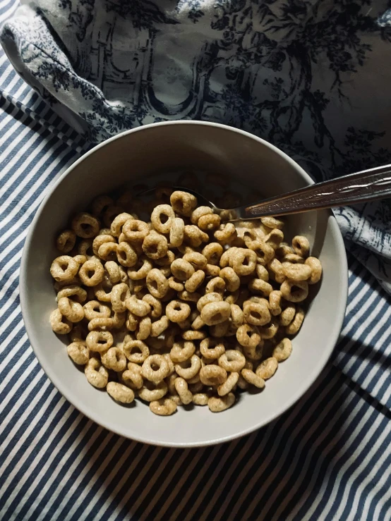 a bowl filled with some cereal and cereal spoons