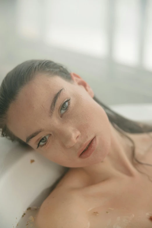 an attractive woman laying down in the bathtub