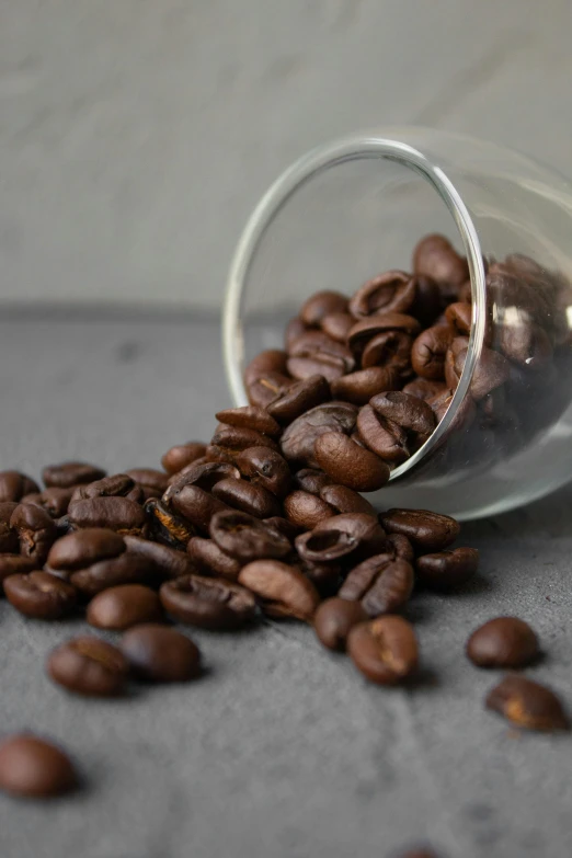 a close up of a glass cup filled with coffee beans