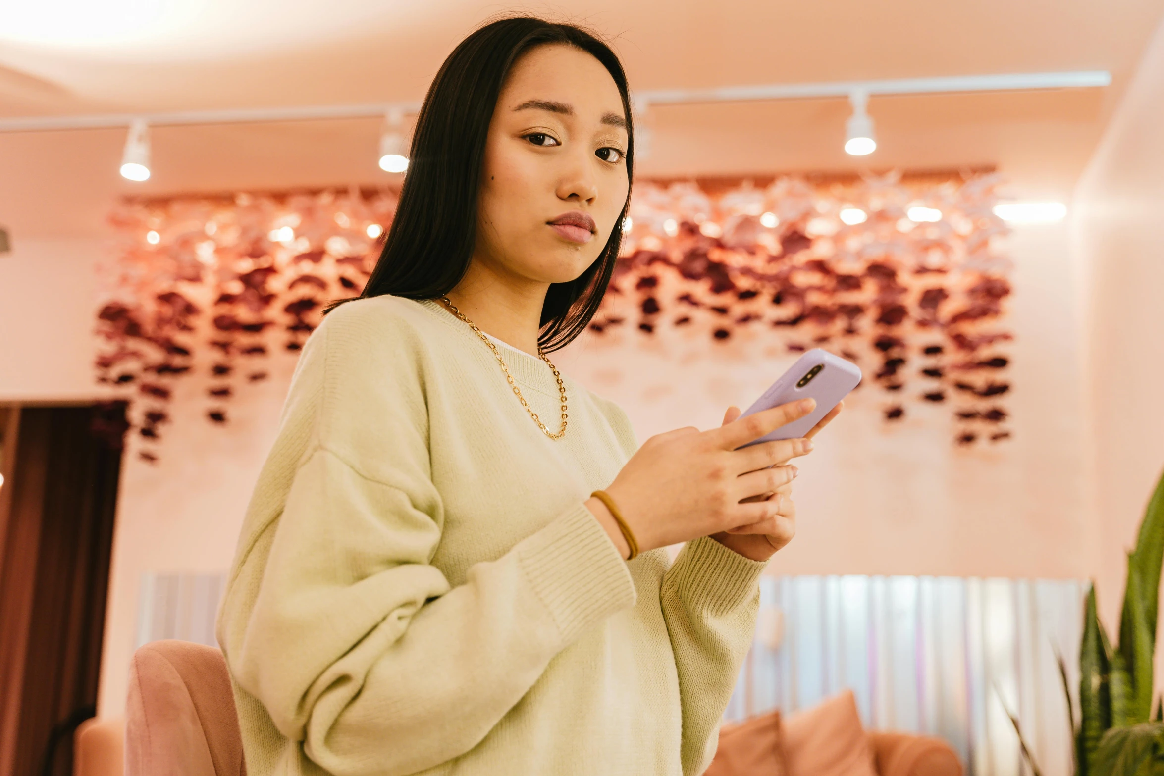 a woman holding a phone while standing in a room