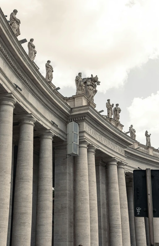 black and white pograph of tall pillars with people walking around