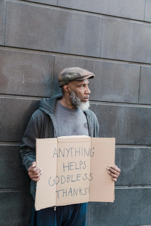 a man with a funny sign on his face holding a cardboard sign