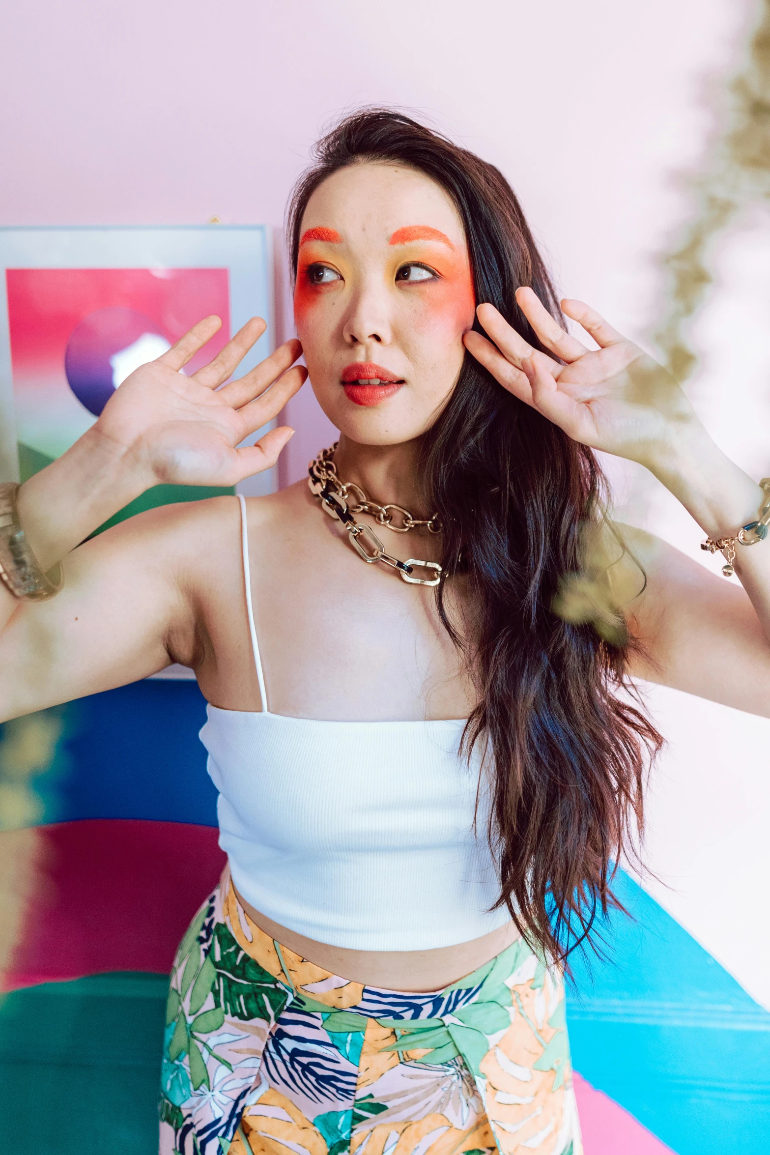 woman with her hands on her head with colorful makeup