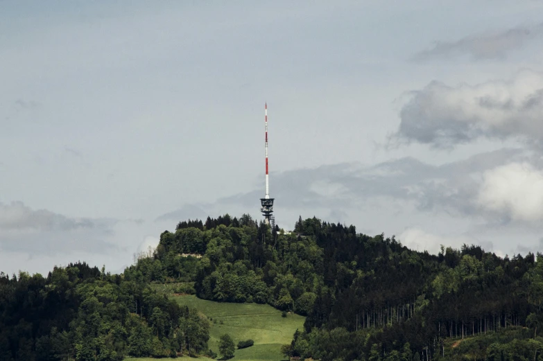 two airplanes flying low over a hill with a television tower in the distance