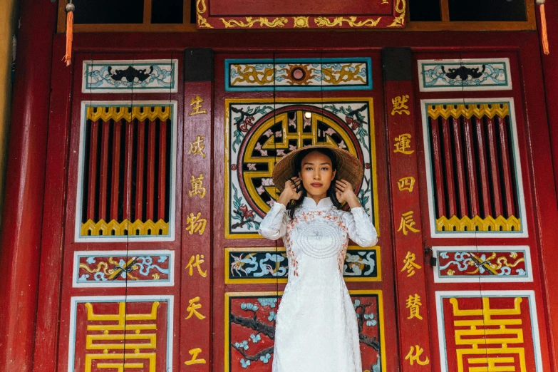 a  stands in front of an oriental doorway