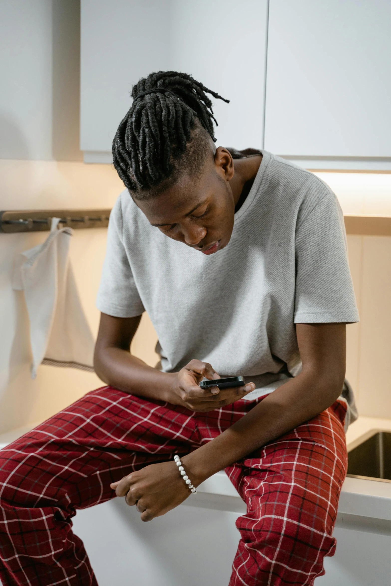 a man in plaid pants is holding a cellphone