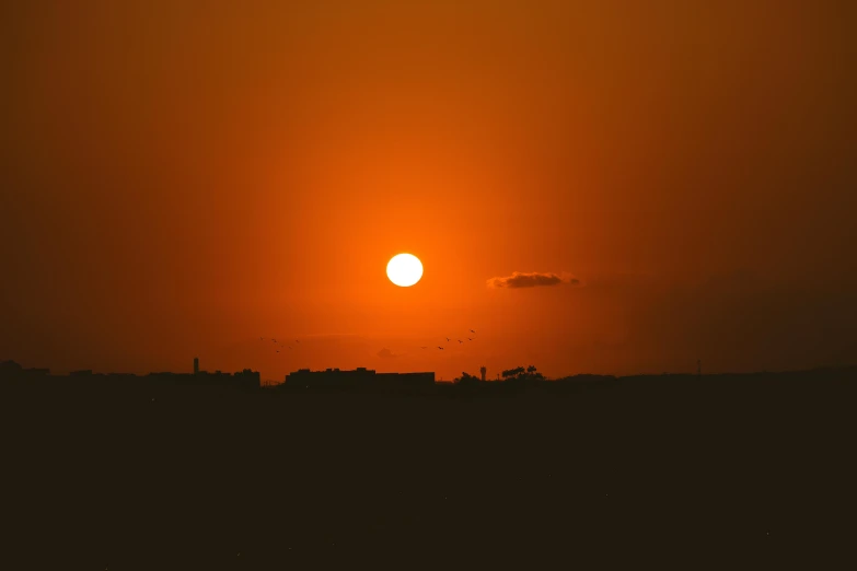 a large body of water with a sun in the background