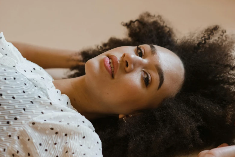 woman laying on floor with head in air and hair down