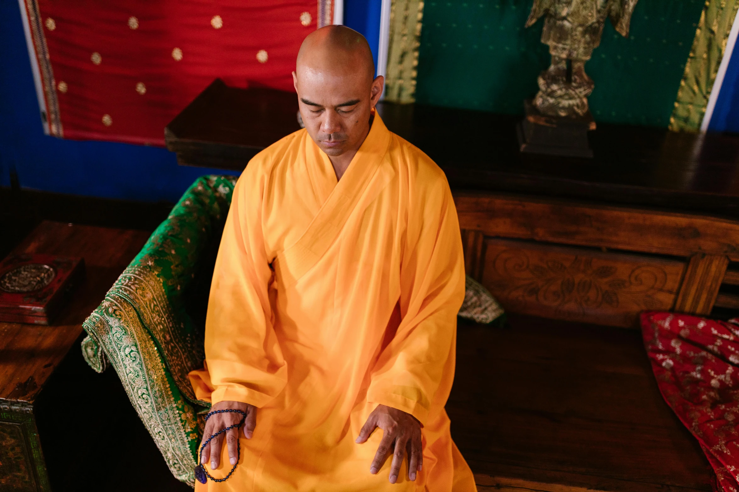 a man in an orange robe is walking on the floor