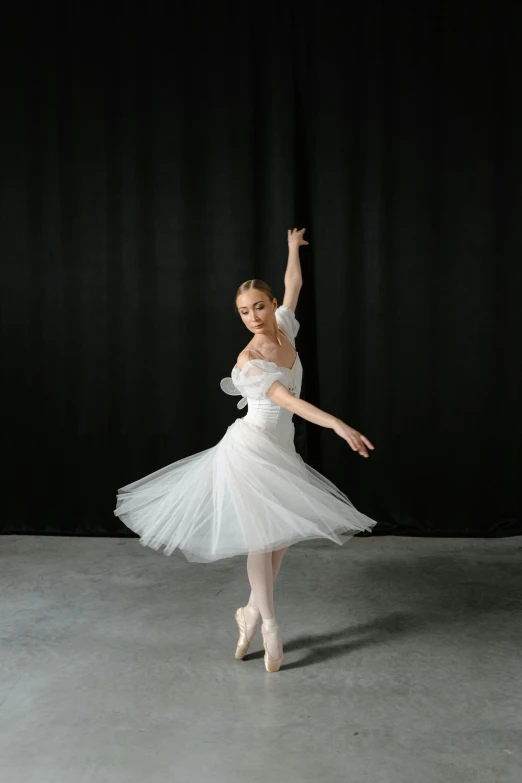 a ballet performance featuring a white dress and a ballet shoe