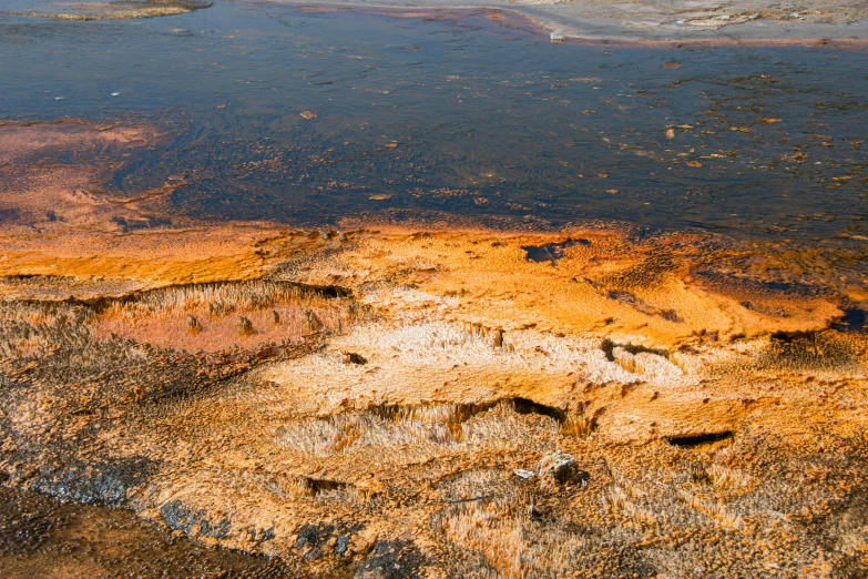 the surface of some orange, yellow and black rocks