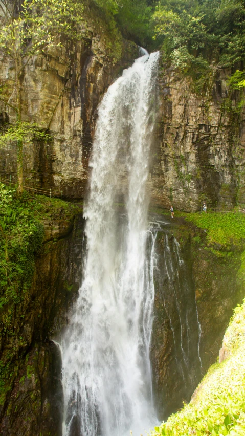 a couple is near the large waterfall