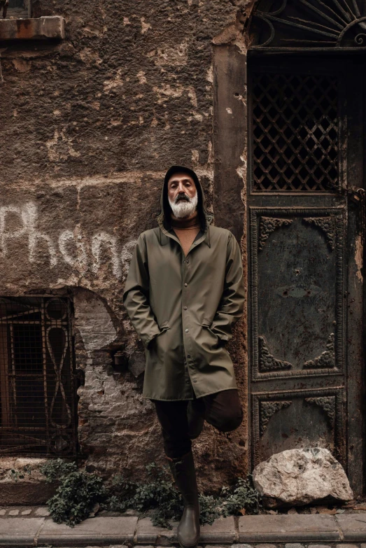 a man stands on the street next to an old building