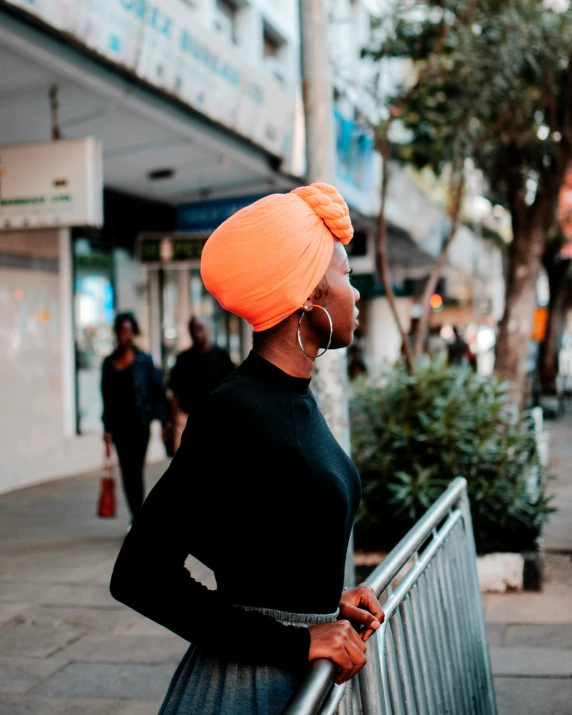 woman in a turban standing on the sidewalk