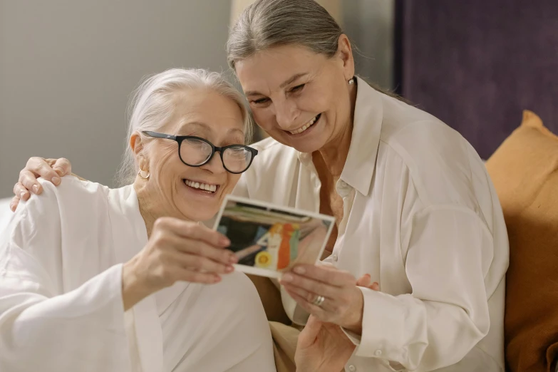 a senior woman and her carer are smiling and looking at the camera
