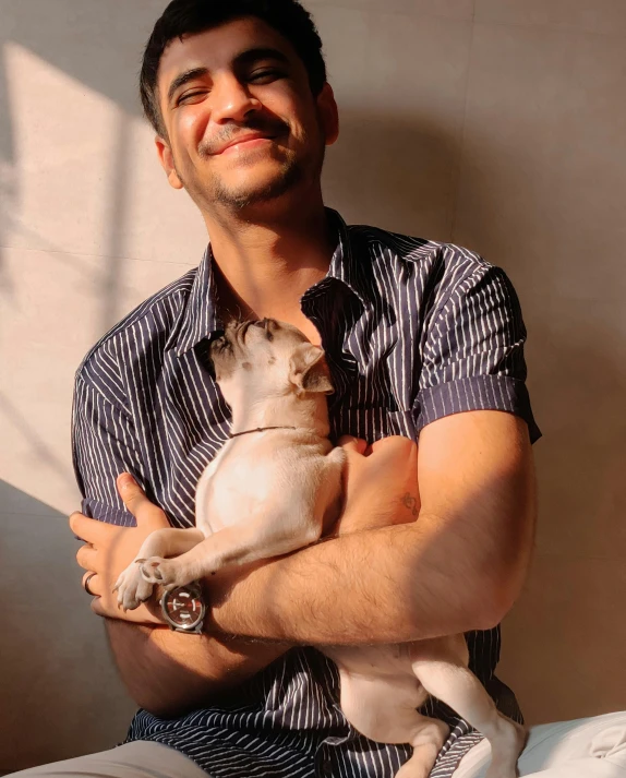 a smiling man holding a little white dog