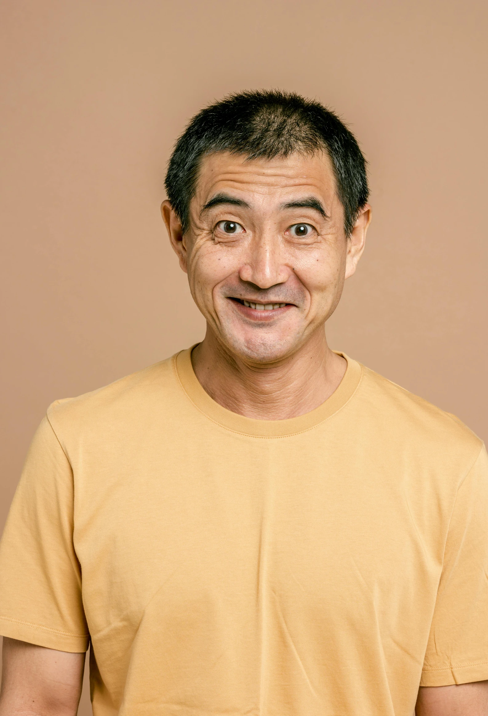 a smiling man posing with his teeth raised