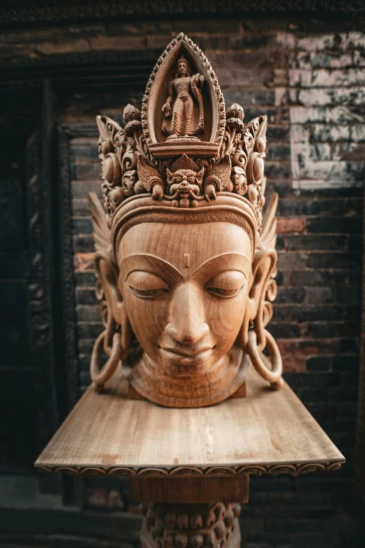 an ornate statue of a woman's head on a wooden platform