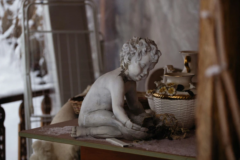 a statue of a child sitting on top of a wooden table